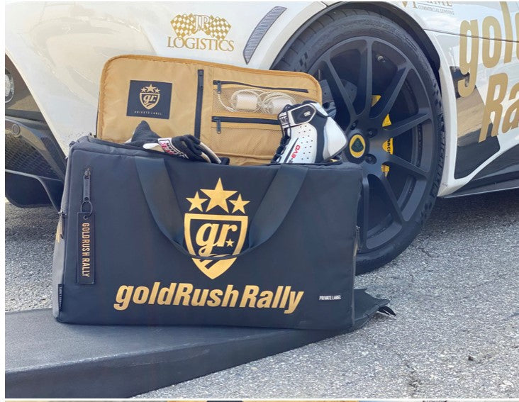 helmet and shoes in the goldRush Rally private label duffle with a race car behind