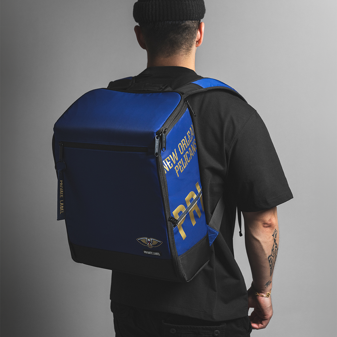 Guy in black clothes wearing a blue pelicans backpack