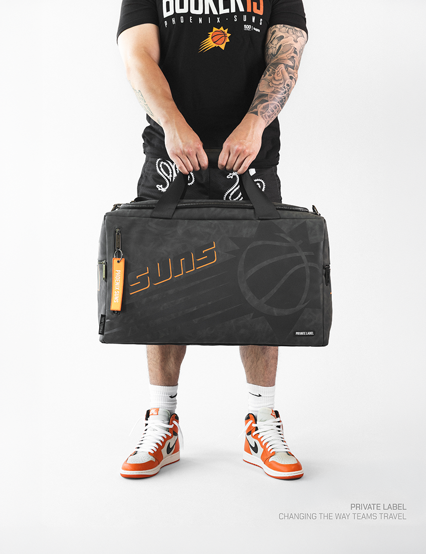 athlete holding a black bag with tonal designs