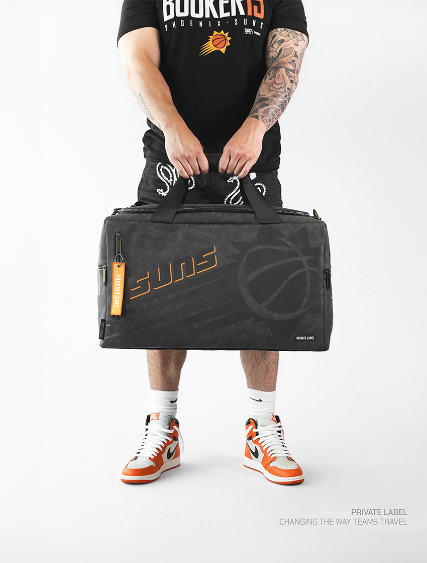 athlete holding a black bag with tonal designs