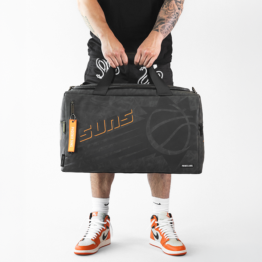athlete holding a black bag with tonal designs