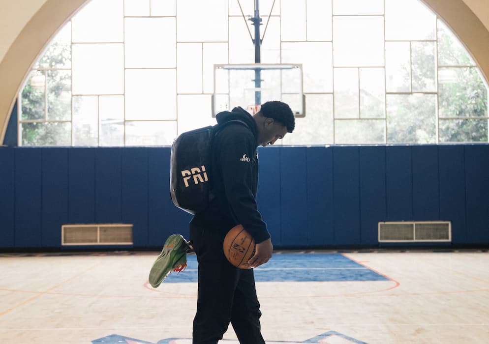 basketball player holding a basketball wearing a private label backpack