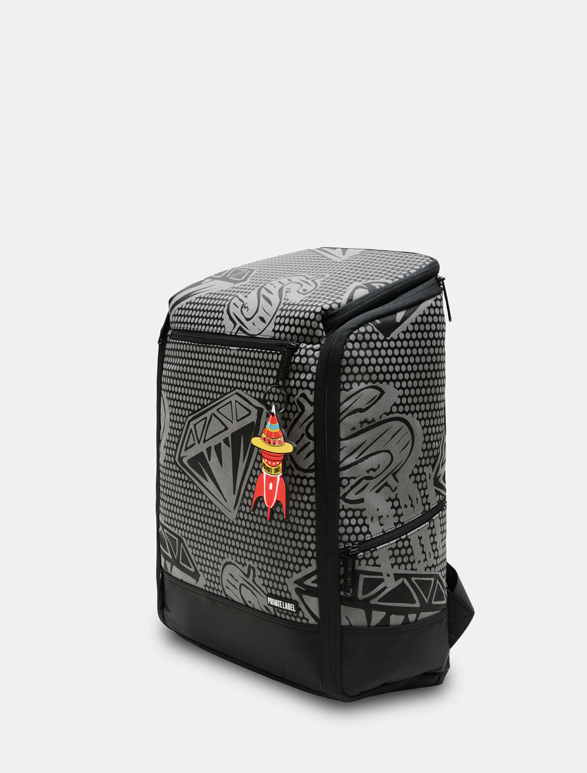 A black and gray patterned backpack with a small red and yellow cartoon character charm hanging from the zipper, shown on a light gray background.