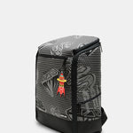 A black and gray patterned backpack with a small red and yellow cartoon character charm hanging from the zipper, shown on a light gray background.
