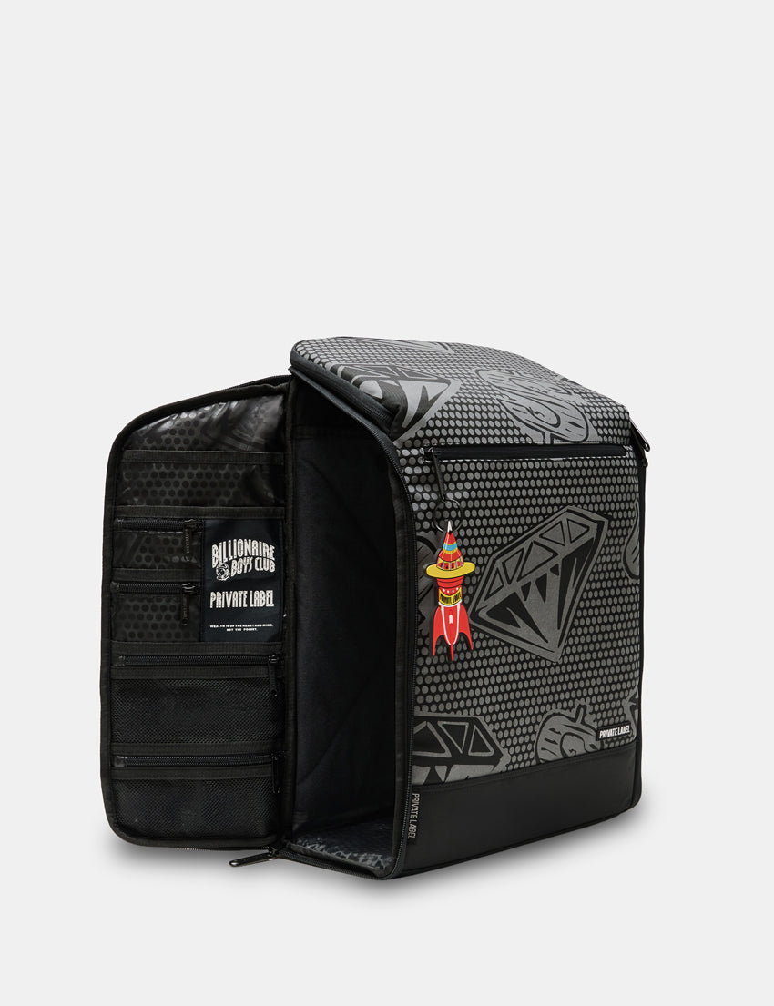 A black and gray patterned gear organizer backpack shown open, displaying its interior compartments and a small red and yellow rocket-shaped patch on the front.