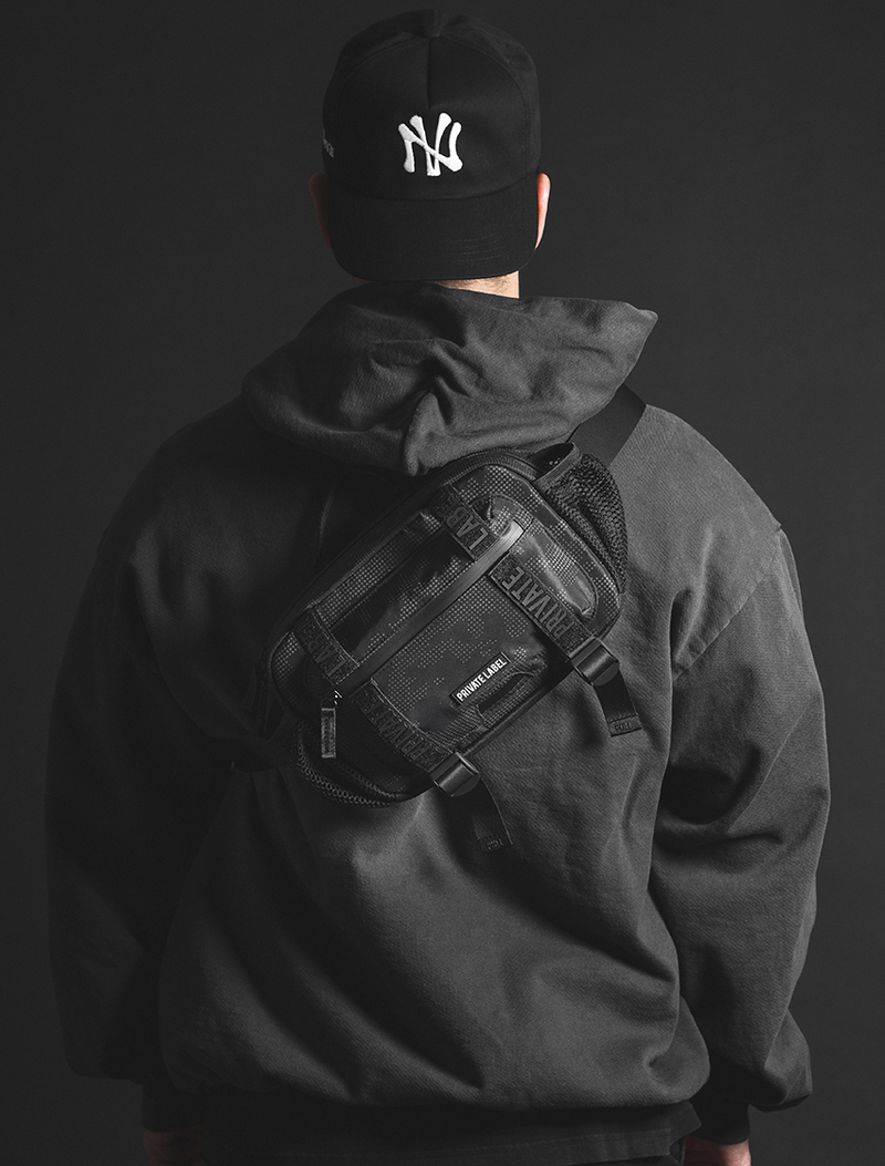 Person wearing a black backpack with a dark background