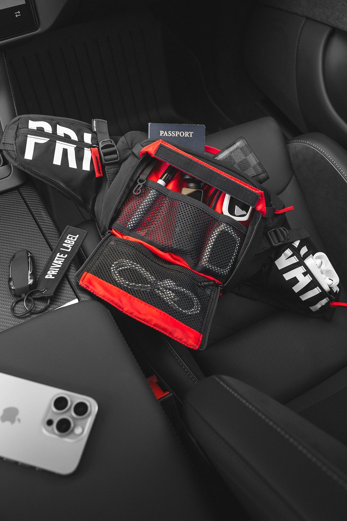 The same sling bag with its front pocket unzipped and folded open, revealing red lining and mesh organizers.