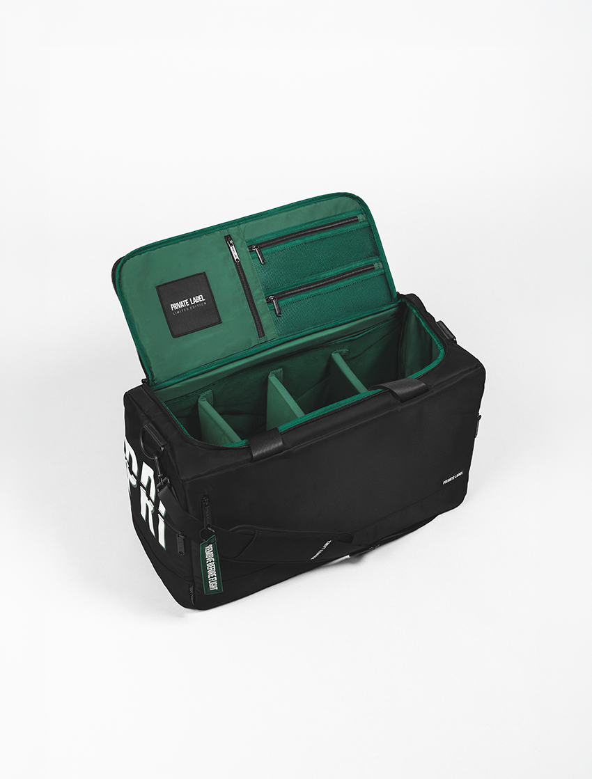 Black duffle with a green interior on a light grey background