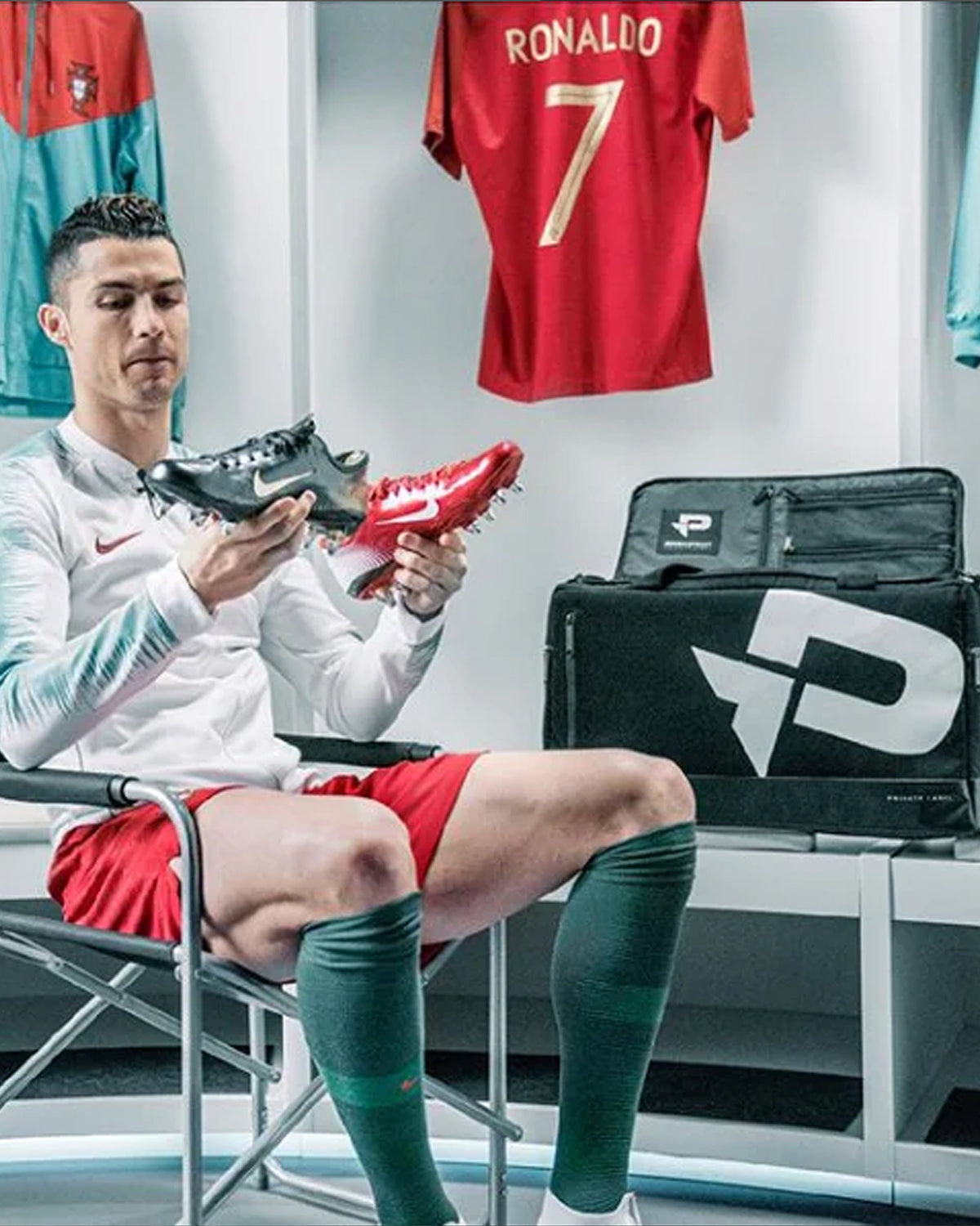 Cristiano Ronaldo holding a pair of soccer cleats in front of a PRO:DIRECT collaborative duffle with private label