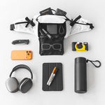 White waist bag surrounded by daily accessories - bottle, headphone, camera and phone