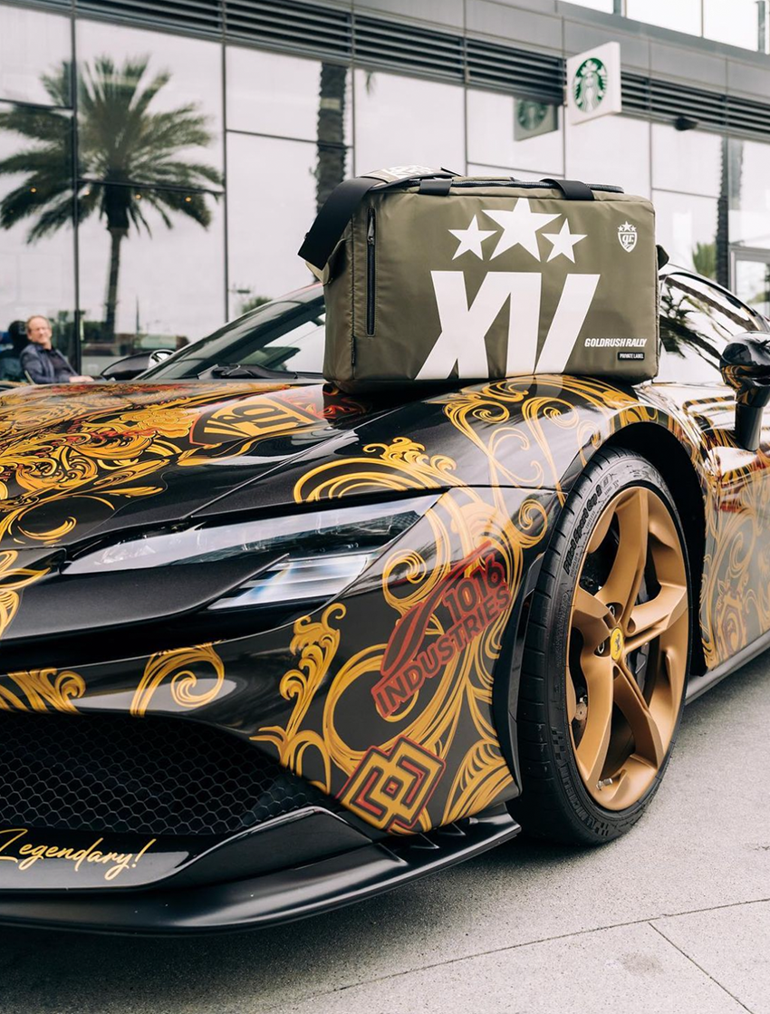Green Gold Rush Rally duffle placed on top of a ferrari with graphics