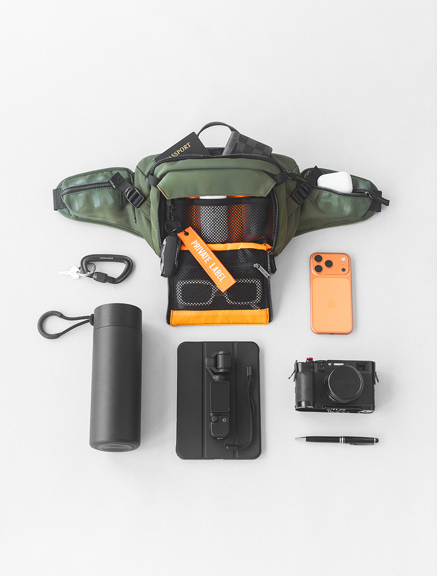 Green Sling Bag with front pocket open & accessories surrounding bag