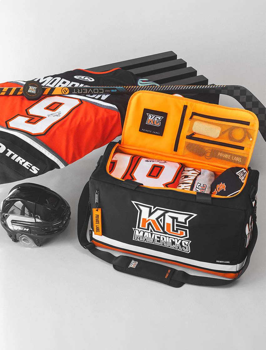 Black and orange racing gear bag with tools, helmet, and branded items on a white background