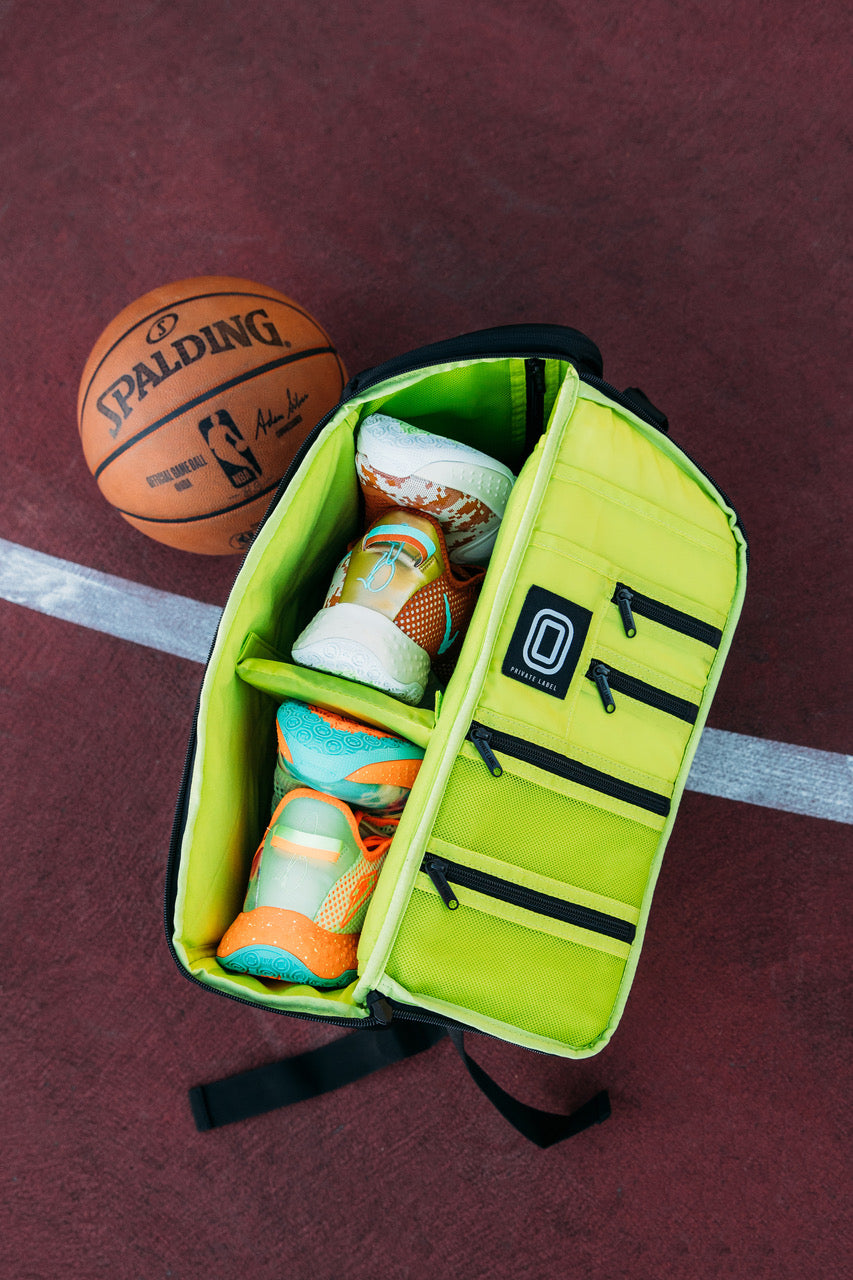 shoes packed inside a black bag with neon green interior