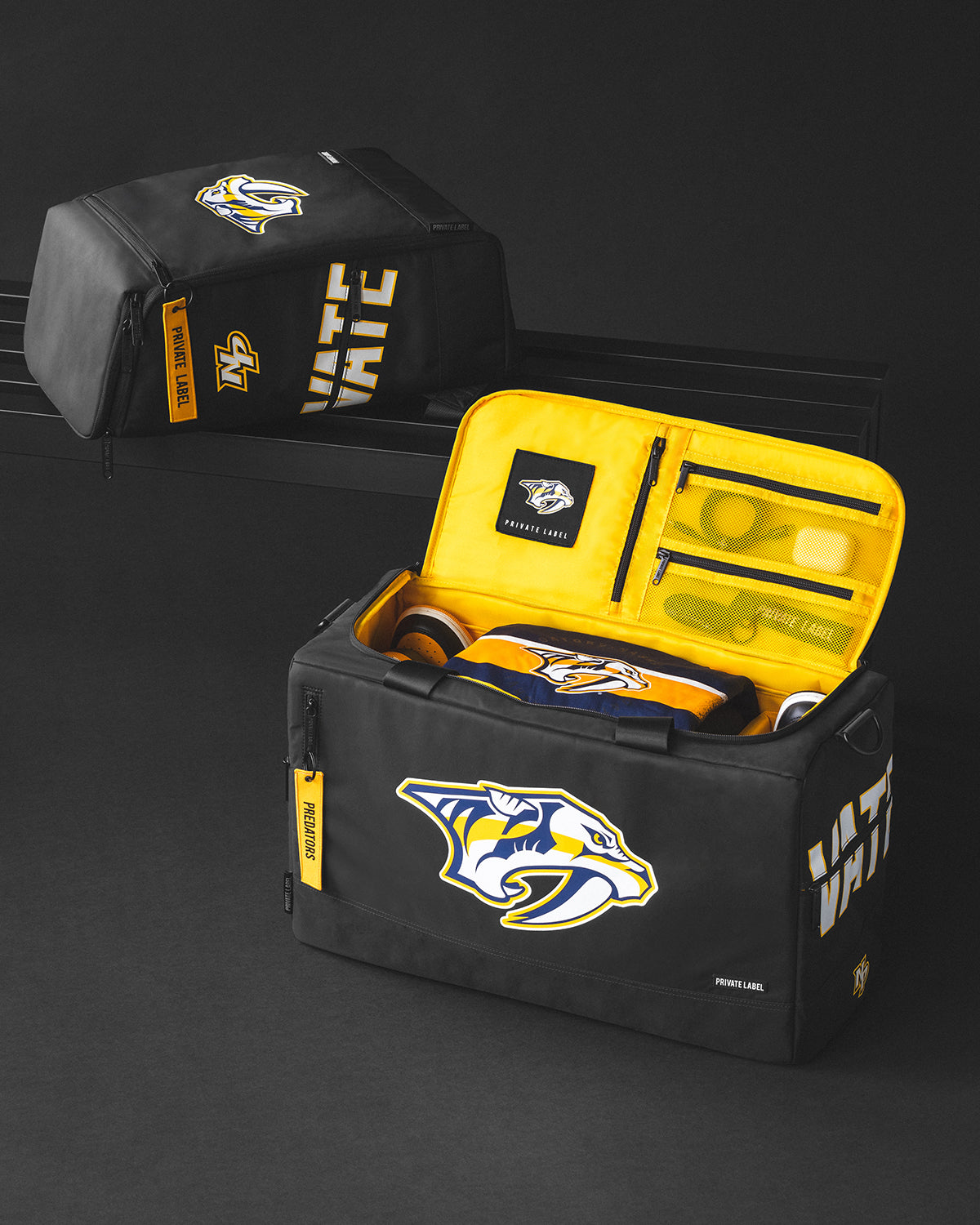 Black duffle with predators logo with a yellow interior alongside a matching backpack