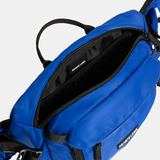 Blue sling bag with black straps on a light gray background