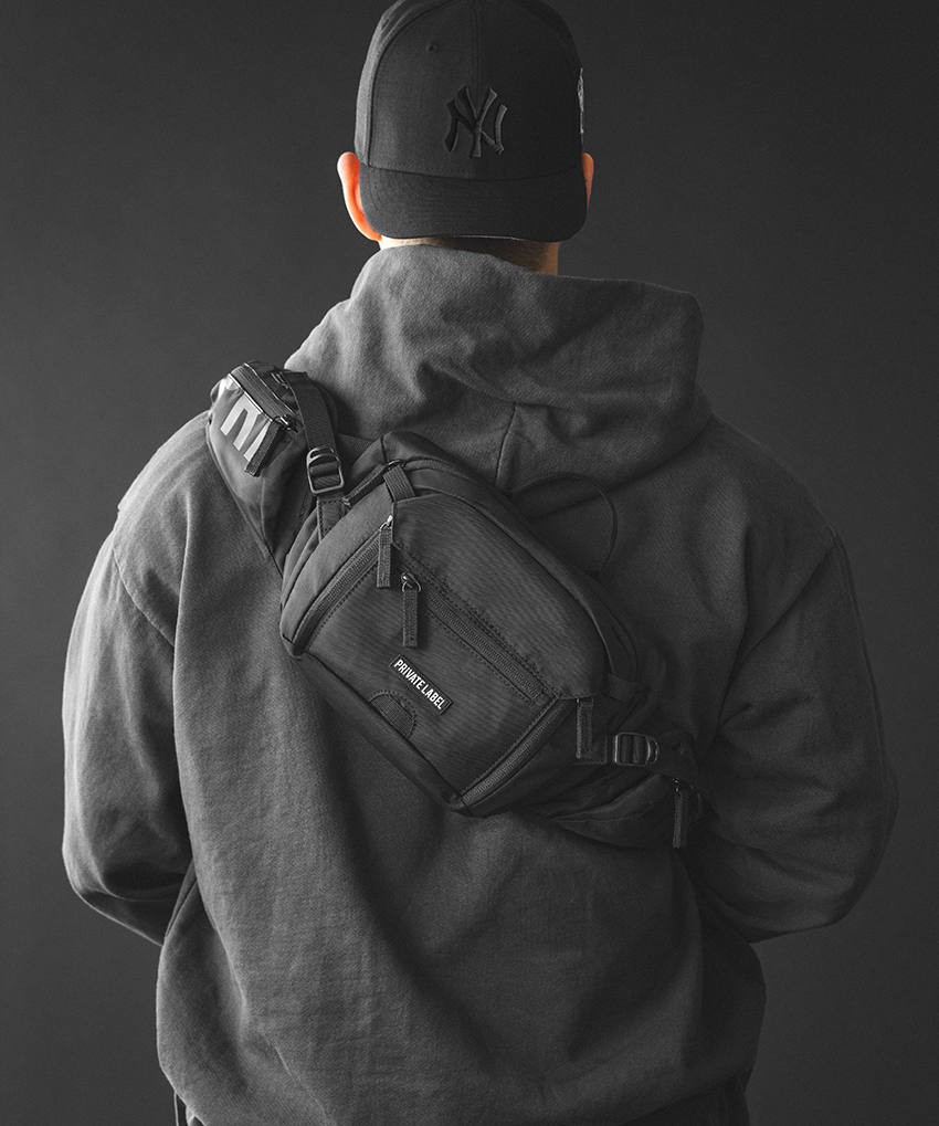 model wearing a black waist bag on his bag on a dark gray background