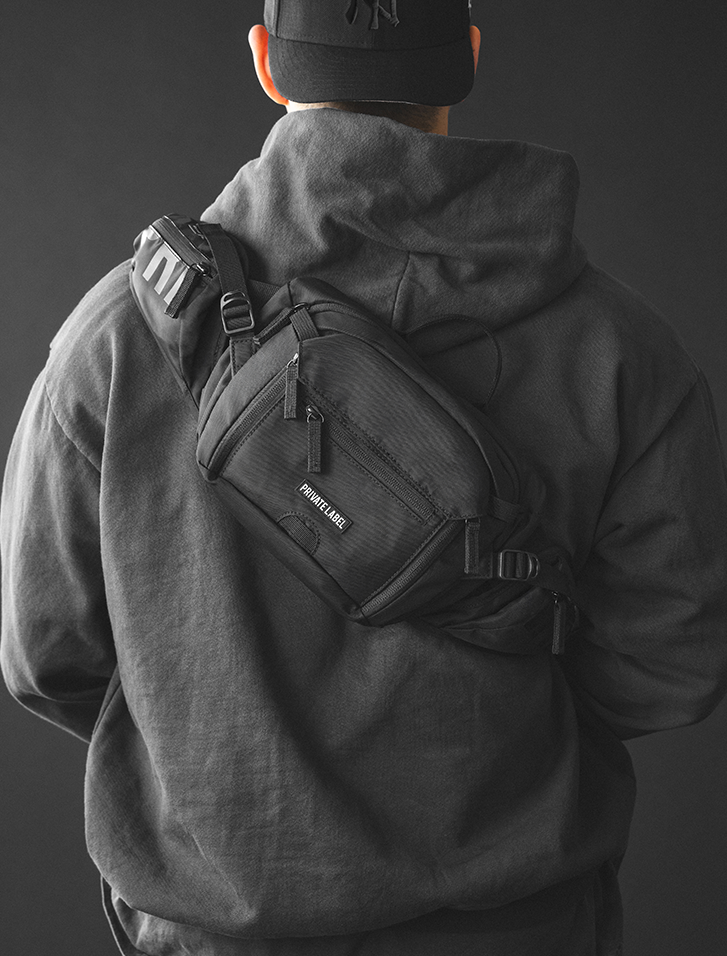 model wearing a black waist bag on his bag on a dark gray background