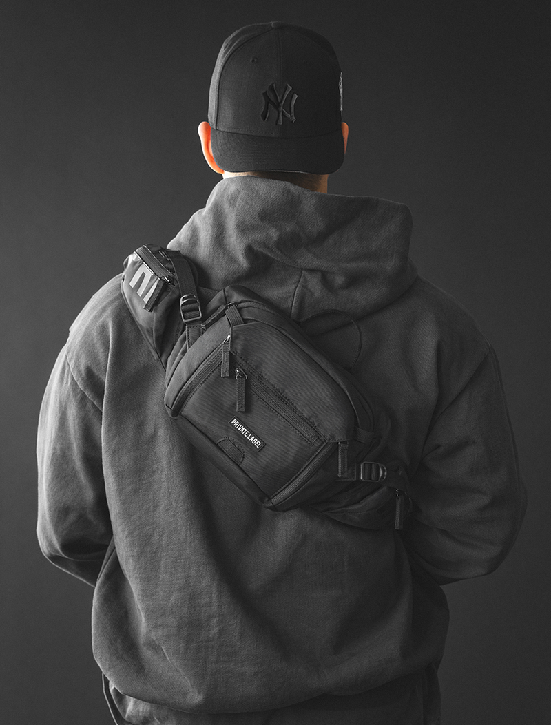 model wearing a black waist bag on his bag on a dark gray background