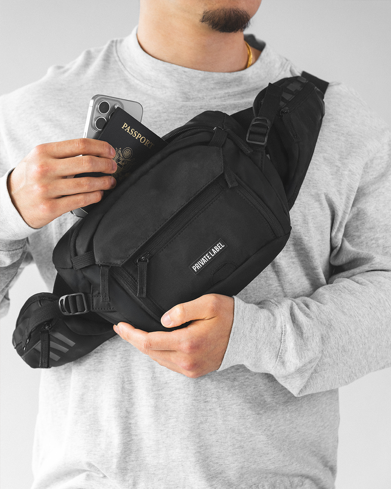 model wearing a black sling bag on front chest on a light gray background