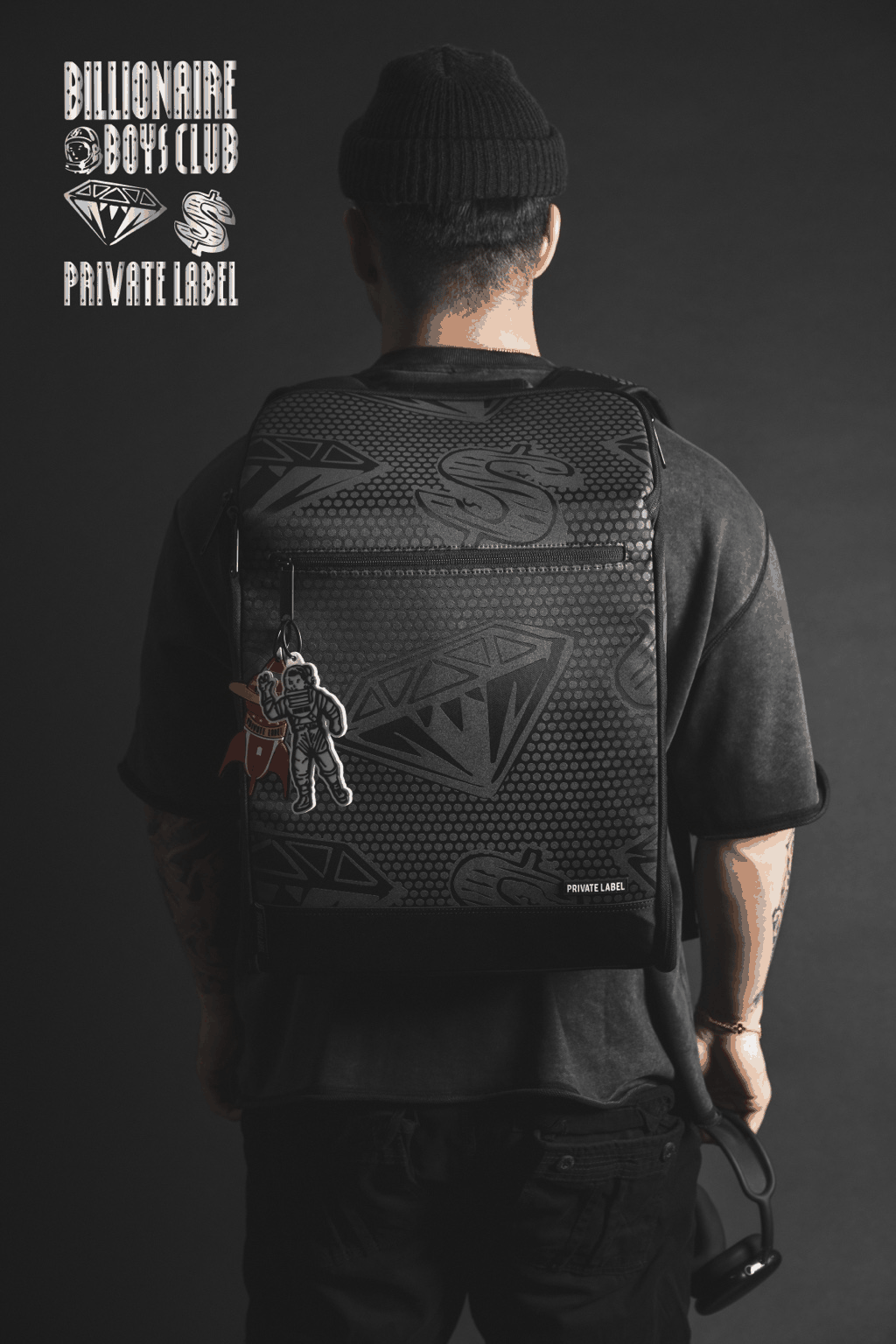 Gif of a Model wearing a reflective backpack with diamond & dollar pattern on a dark background