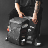 model sitting next to an open backpack containing assorted items such as shoes & clothes + accessories