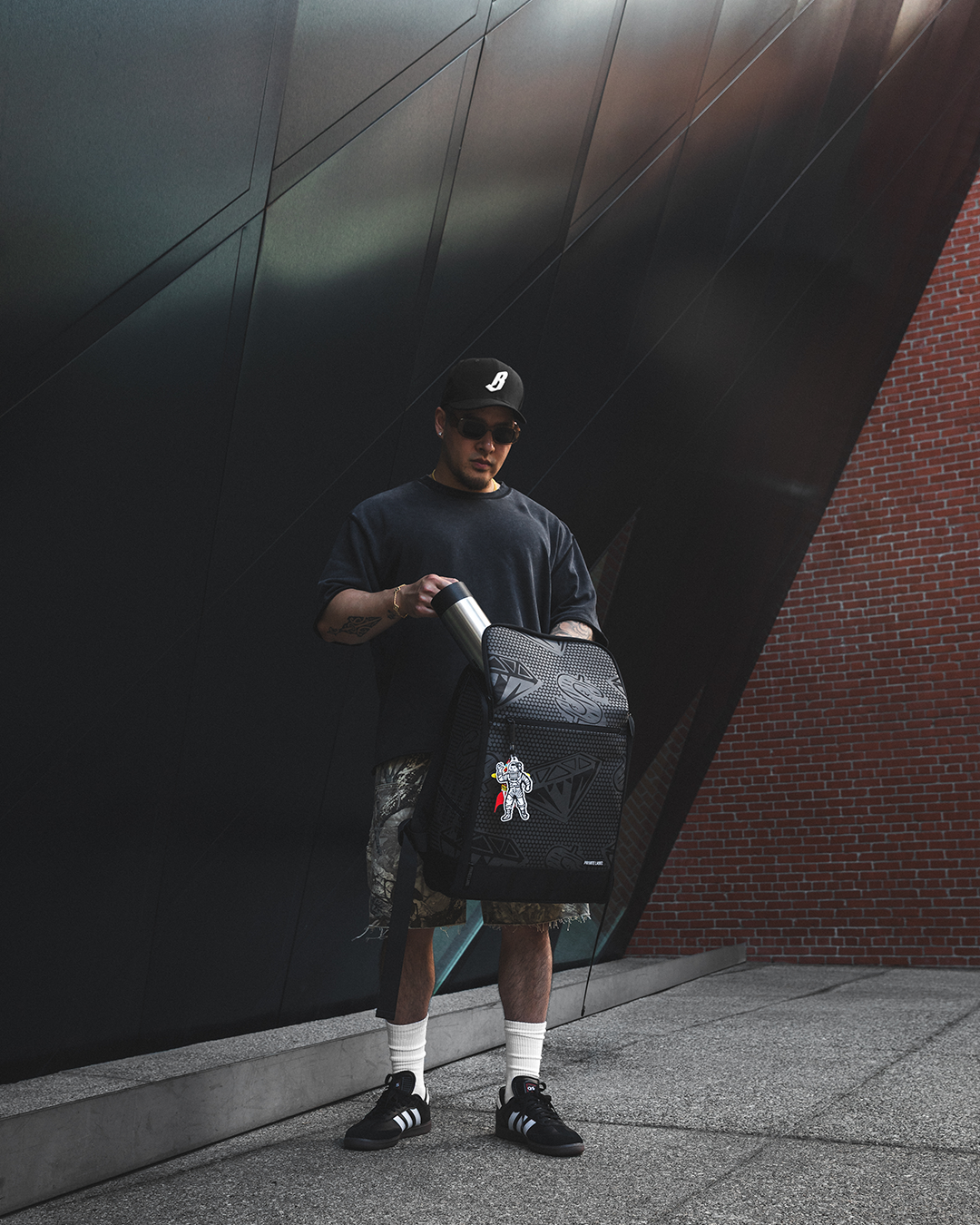 Model holding a backpack & taking out a water bottle