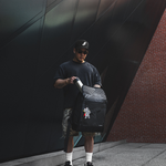 Model holding a backpack & taking out a water bottle