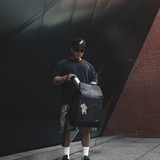 Model holding a backpack & taking out a water bottle