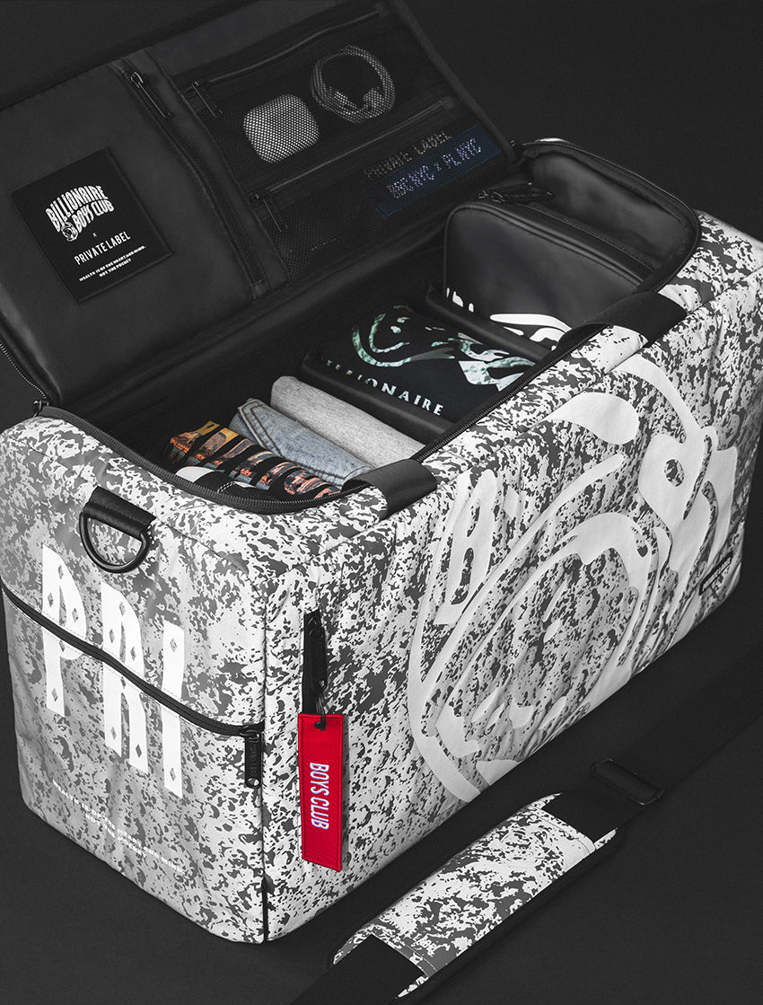 a reflective moon pattern duffle bag with billionaire boys club clothes packed inside,