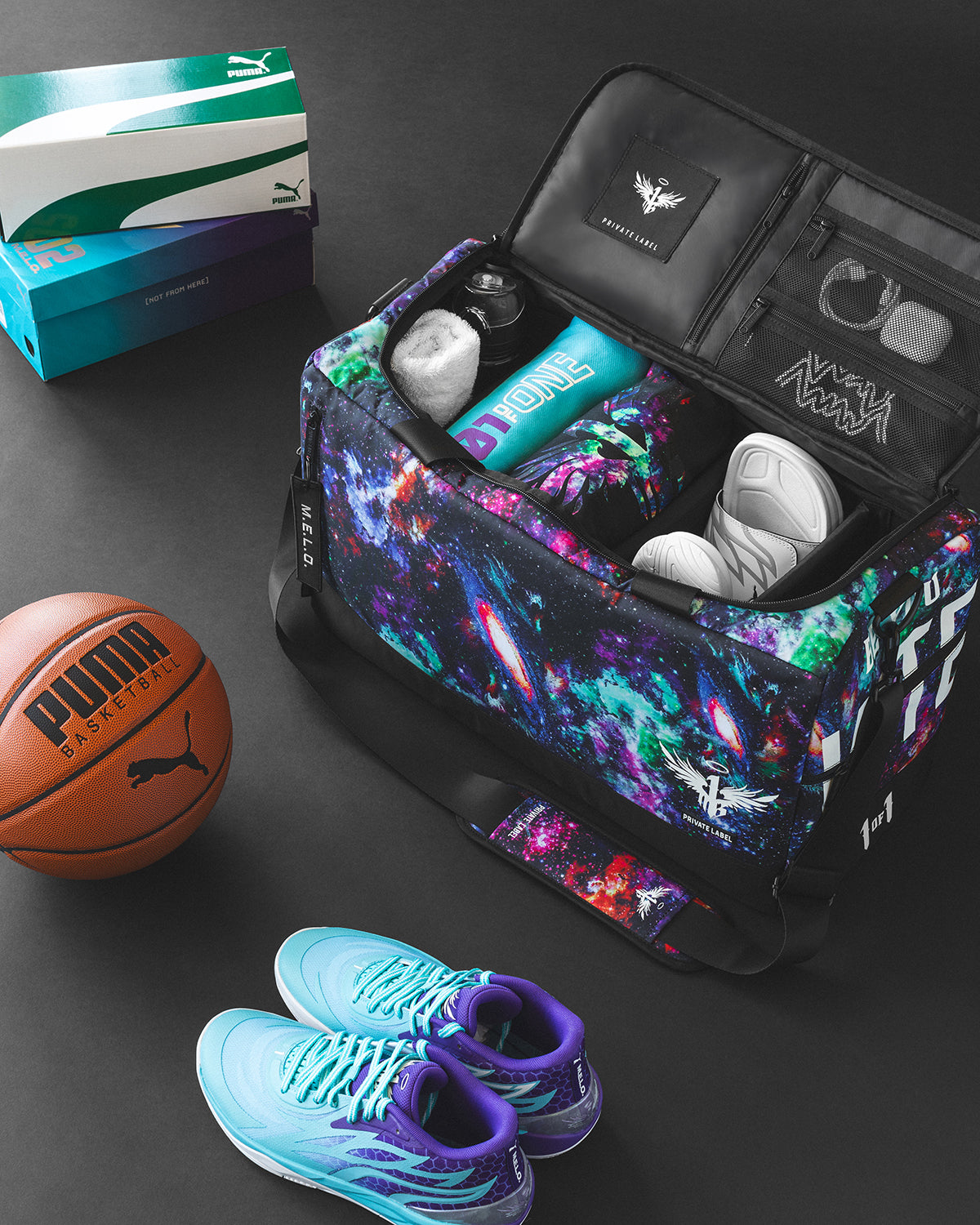 A galaxy patterned duffle with basketball accessories surrounding the back and apparel packed inside the duffle