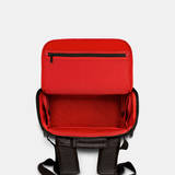 Black backpack with red interior opened from the top 