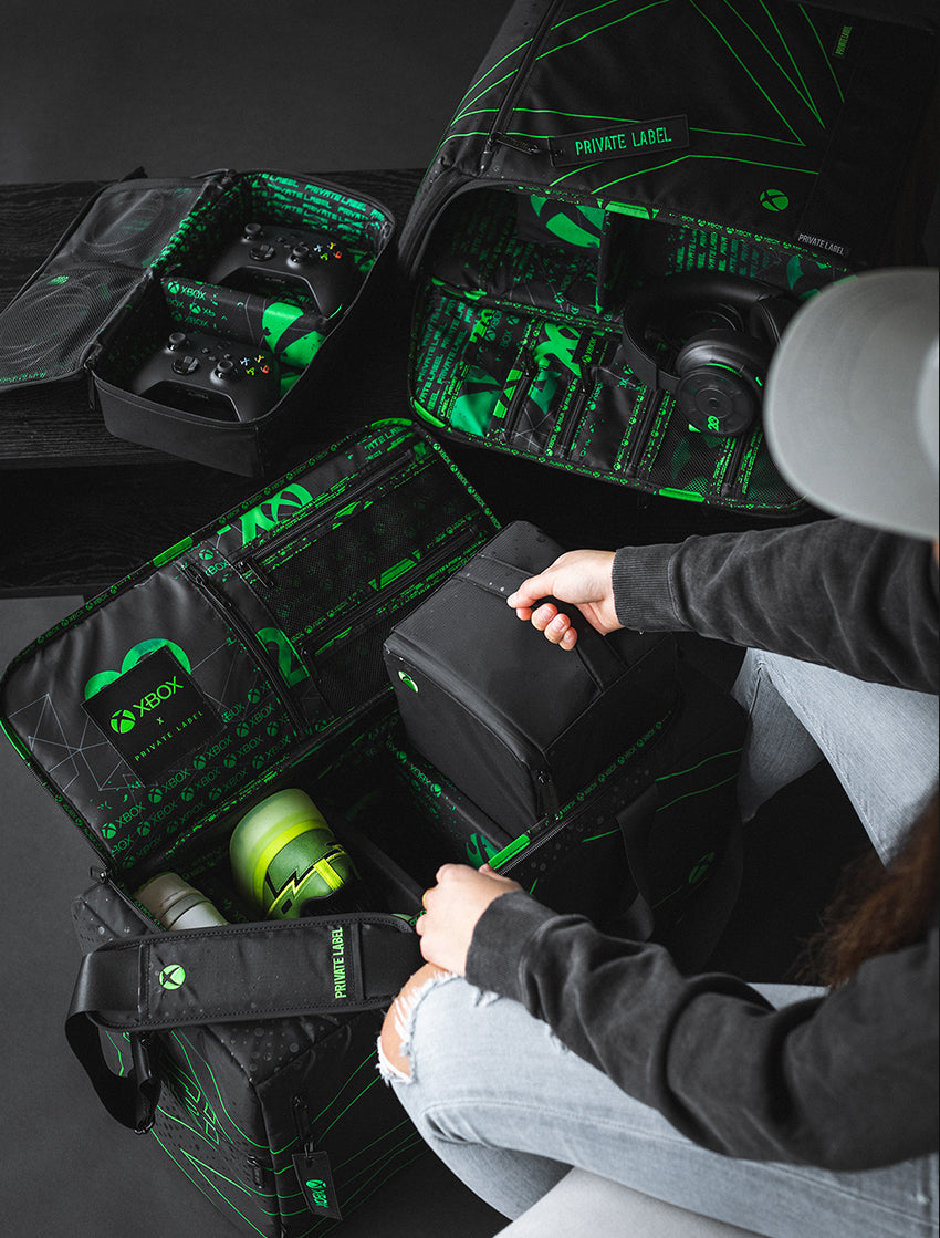 model taking out a smaller travel case from an XBOX branded private label duffle bag